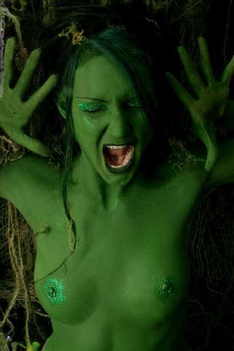 Solo girl with green skin wanders around the woods with no clothes on