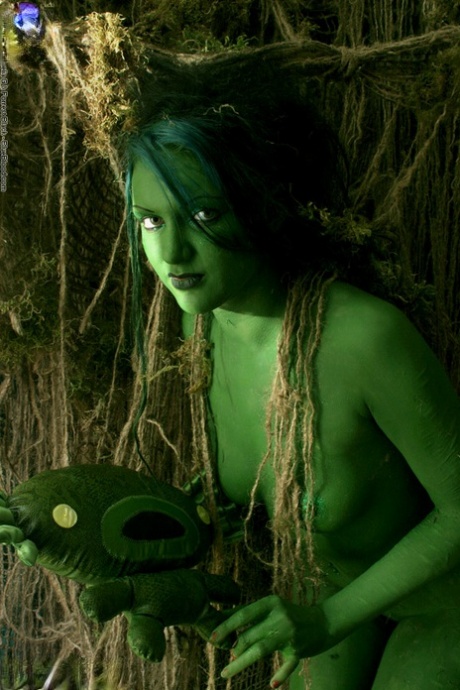 Solo girl with green skin wanders around the woods with no clothes on