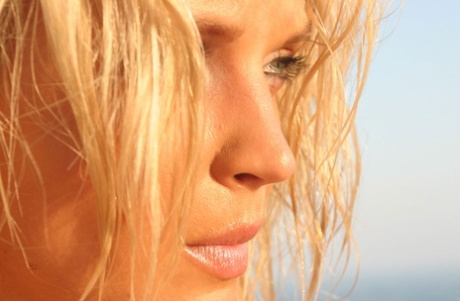 Hot blonde Ines Cudna releases her huge tits from bikini alongside a seawall