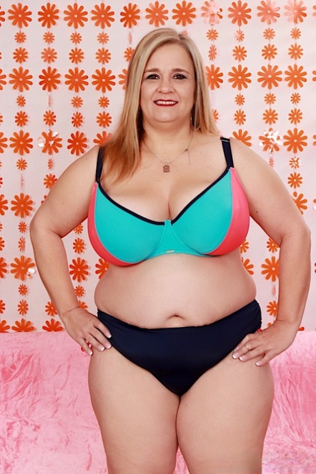 Fat blonde Cami Cooper gets naked before sex with a machine dildo on a futon