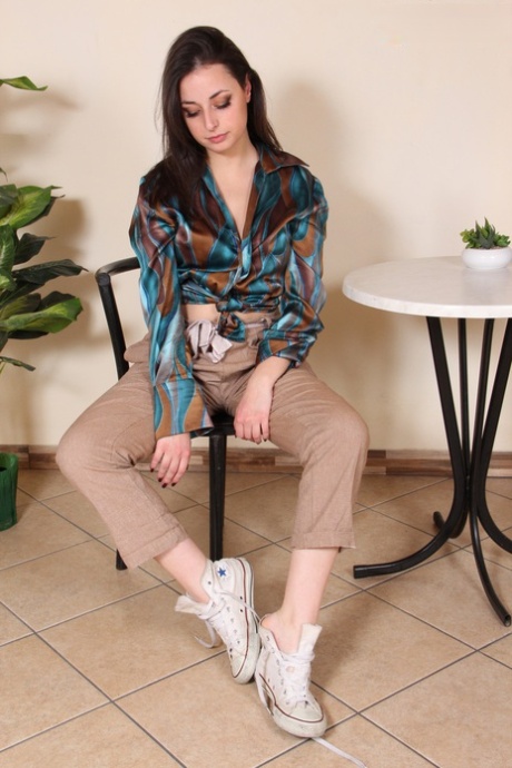 Fully clothed brunette Ilaria frees her beautiful feet from canvas sneakers
