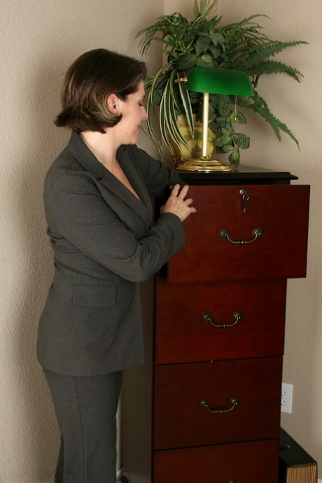Middle-aged businesswoman Jocelyn spreads her pussy after undressing