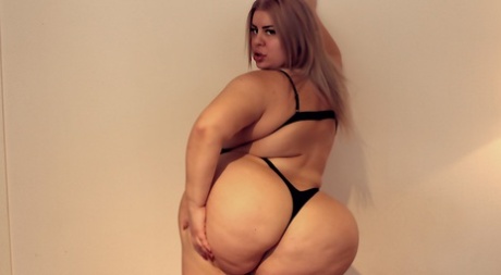 MILF fatty Natasha Crown showing off her marvelous huge ass in a black bikini