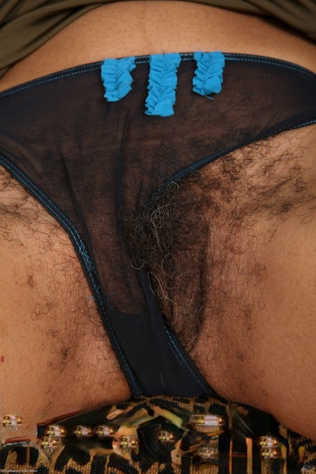 Curly-haired ebony woman Ariela undresses and displays her hairy crotch