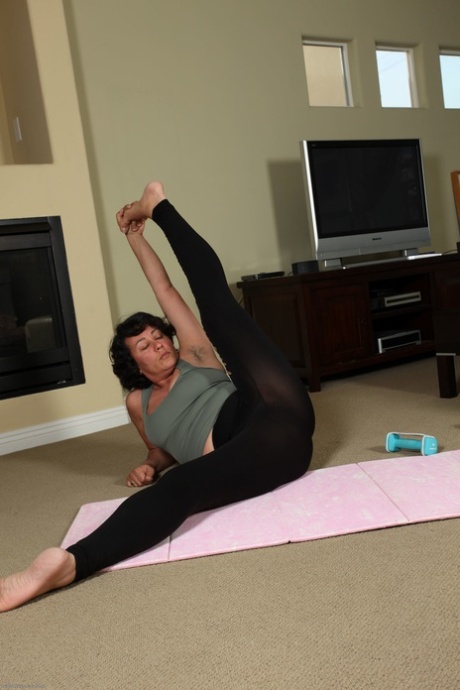 Mature woman Desiree strips after her yoga session & spreads her hairy crotch