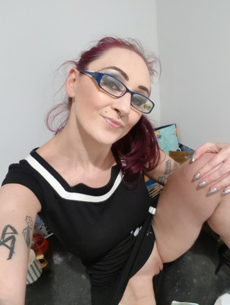 Nerdy amateur redhead Demona Dragon presents her amazing tits and twat