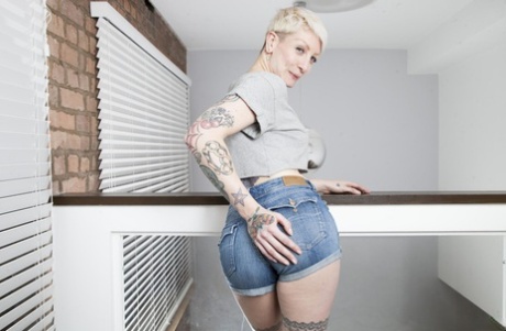 Short-haired British girl Miss Trixx strips & flaunts her big booty